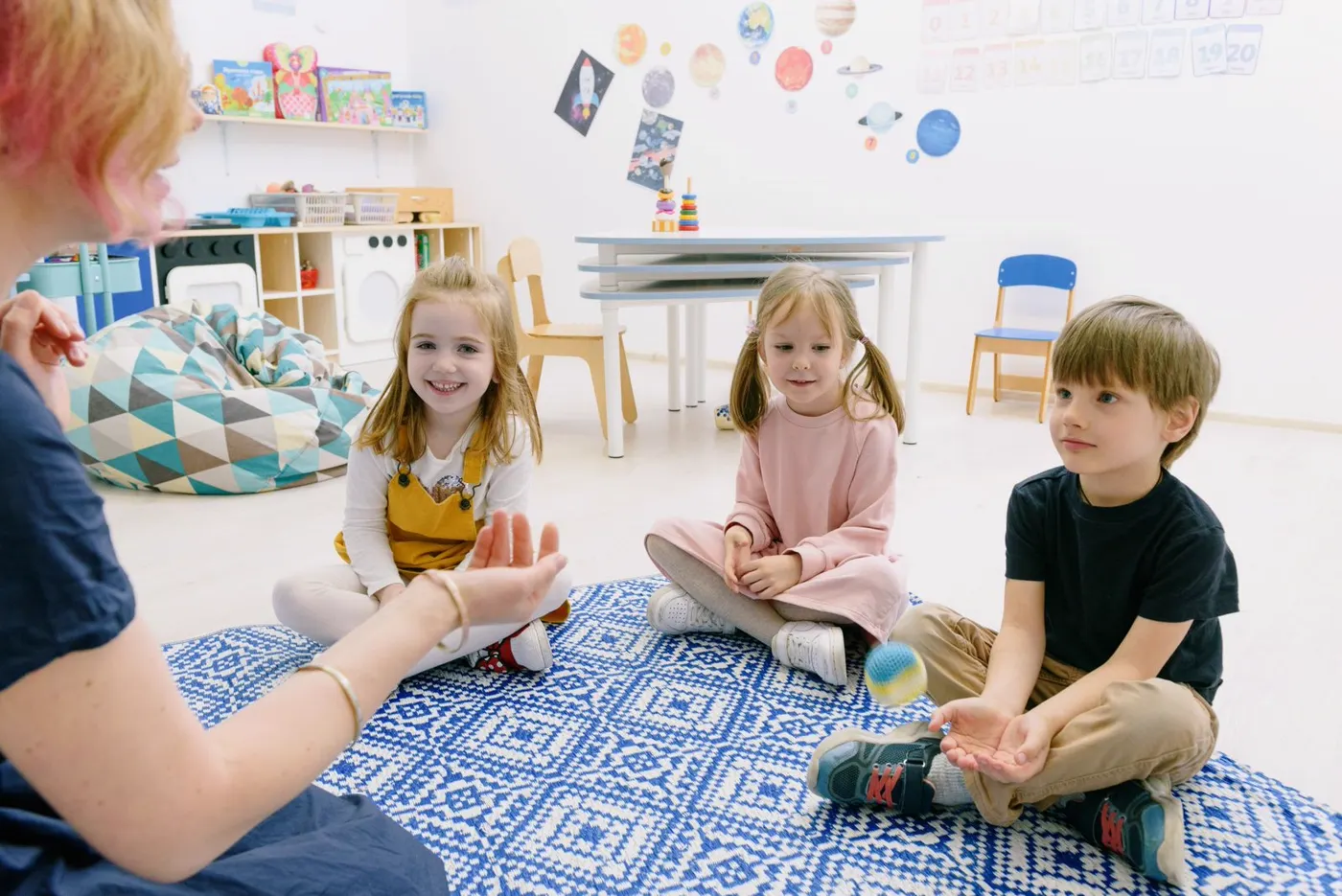 Teacher greeting children warmly in a bright, welcoming classroom