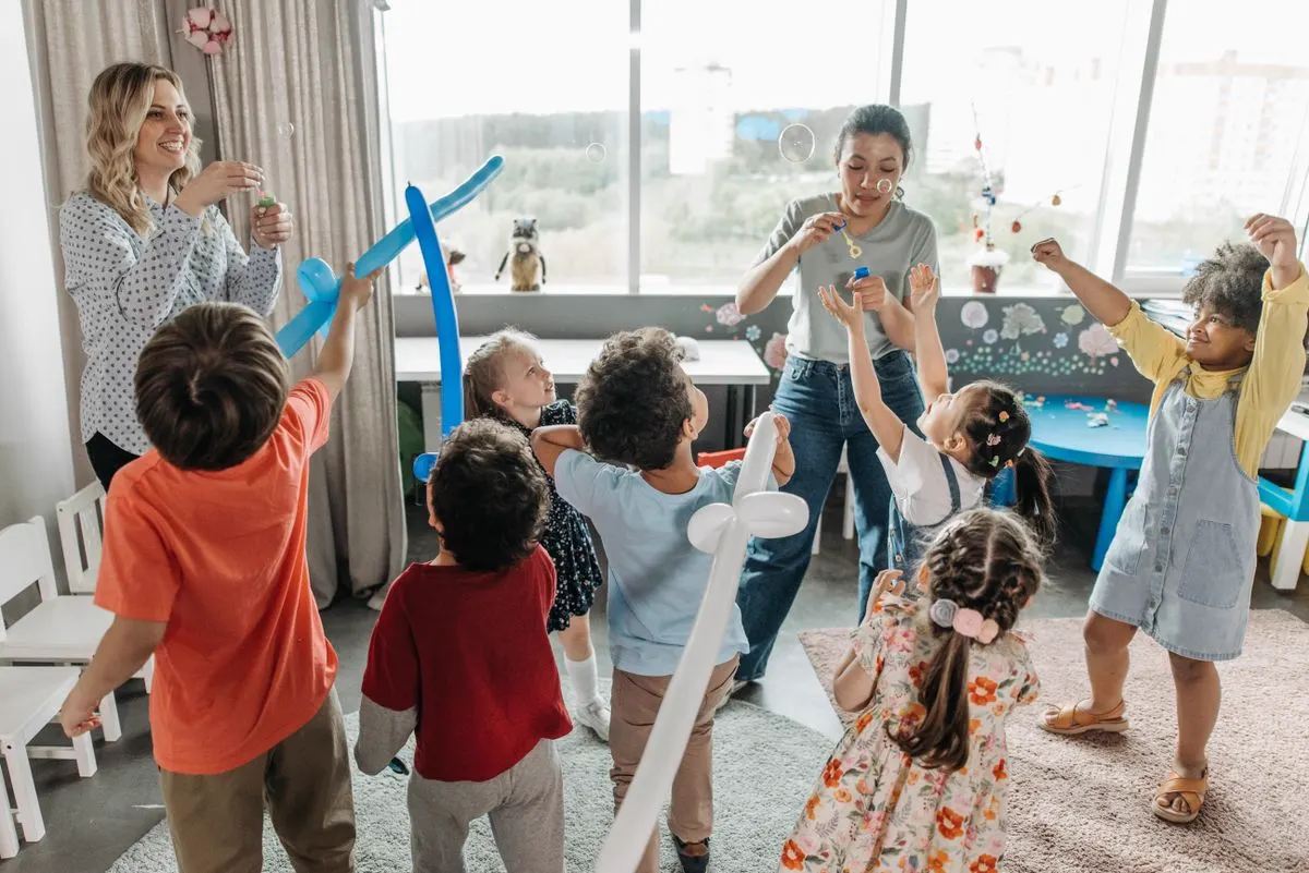 Teacher and children celebrating together in a bright, colorful classroom